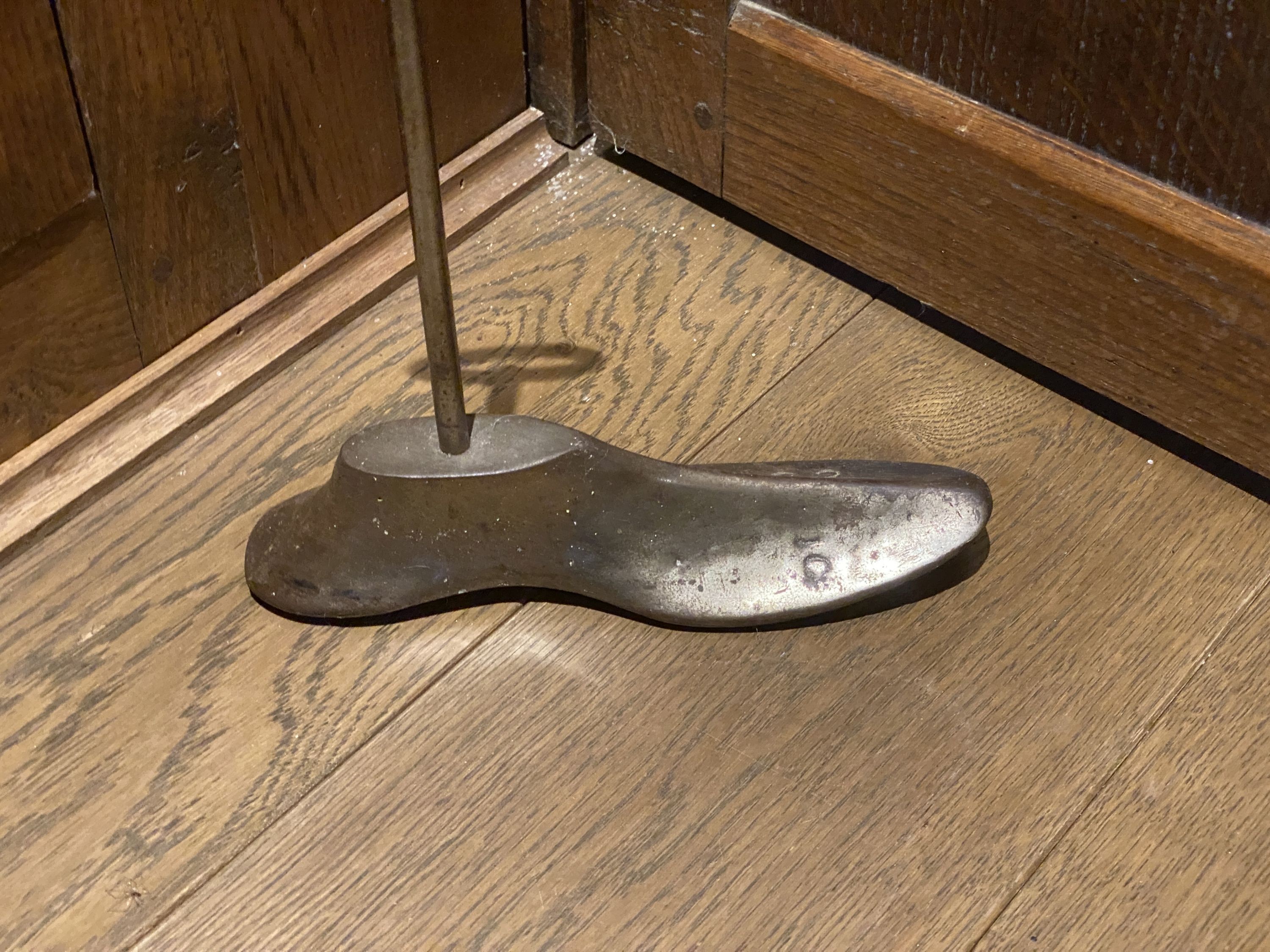 A door porter made from brass and steel with a shoemaker's last, height 39cm